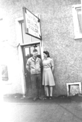 Two unidentified persons in front of New Ray Beauty Parlour, Dawson Creek, BC, 1942-1943