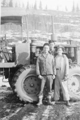3 unidentified men standing beside a piece of heavy machinery, Camp 2, Hart Highway, B.C. April 1946