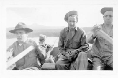 4 unidentified uniformed men in a rowboat, 2 are rowing and 2 hold fishing rods, Alaska Highway 1941-1944